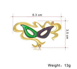 Dettaglio della spilla a maschera di carnevale con dimensioni 6,3cm x 3,5cm e 13g
