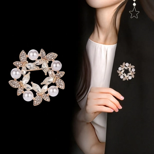 Elegant gold flower wreath brooch with pearls and crystals shown on black blazer
