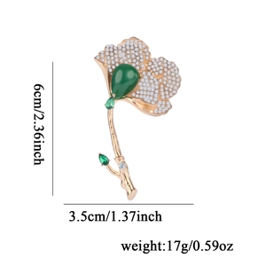 Golden ginkgo leaf brooch with white rhinestones and a large green teardrop gemstone