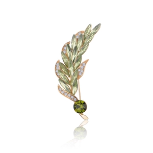 Elegant gold wheat brooch with green marquise gemstones and white rhinestones on white background
