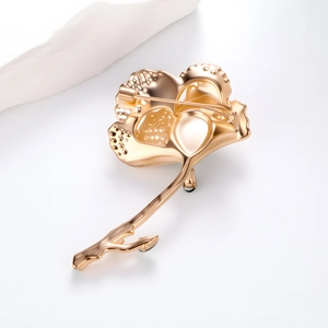 Back view of gold leaf brooch showing horizontal safety pin clasp and textured metal finish
