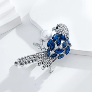 Broche oiseau exquise avec cristaux bleus et une grande perle blanche en argent