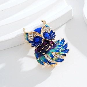 Close-up of owl brooch showing gradient enamel feathers and sparkling rhinestones