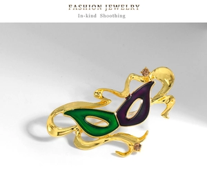 Dettaglio della spilla a maschera con smalto verde e viola e cristalli color champagne