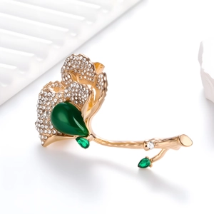 Detail of green ginkgo leaf brooch with teardrop stone and crystal pavé on metal