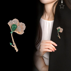 Elegant ginkgo leaf brooch with green teardrop crystal and rhinestones on suit
