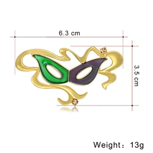 Spilla maschera in smalto verde e viola con dimensioni di 6,3 cm per 3,5 cm