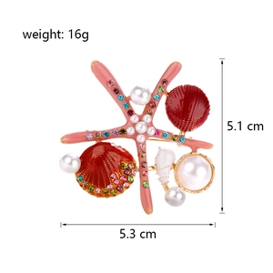 Starfish and shell brooch with pearls and crystals measuring 5.3 x 5.1 cm on white background