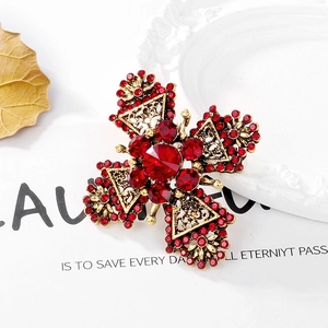 Vintage gold-tone cross brooch with red rhinestones and intricate baroque filigree