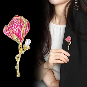 Elegant rose floral brooch with pink enamel, gold finish and pearl drop on black blazer