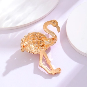 Elegante broche de flamenco chapado en oro con reverso detallado y cierre de seguridad