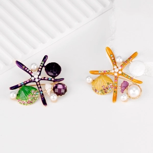 Enamel starfish and seashell brooches with pearls and colorful rhinestones on white silk