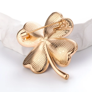 Elegant rose gold clover brooch shown from a 45-degree angle with fine texture detail