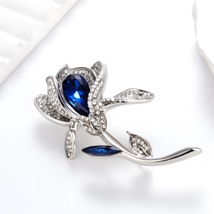 Broche tulpe élégante avec pierre bleue taillée en poire et pavé de diamants sur fond blanc