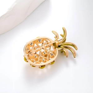 Broche ananas à la mode vue de dos montrant la maille dorée creuse et l'épingle