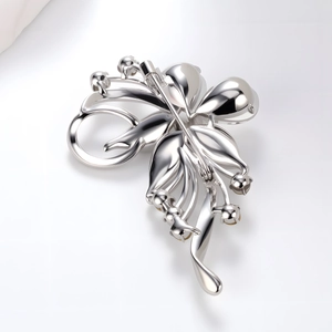 Broche de flor plateada con gemas amarillas y hojas aerodinámicas visto en un ángulo de 45 grados