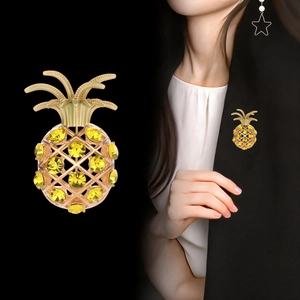 Broche ananas dorée élégante avec cristaux jaunes sur le revers d'une veste noire