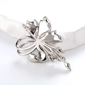 Elegant silver flower brooch with crystal inlay and pearl tassels shown at a 45-degree angle