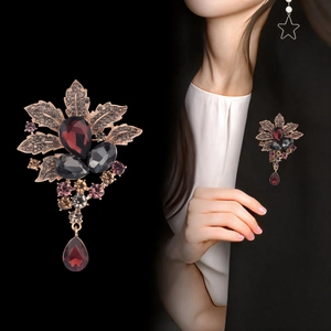 Broche fleur vintage en cristal avec pendentif goutte rouge sur blazer élégant