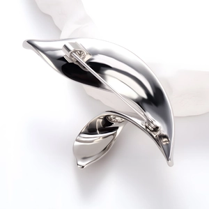 Elegante spilla a foglia argento con design asimmetrico e finitura in metallo lucido