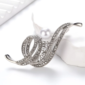 Elegant musical note pearl brooch with sparkling crystals on a minimalist white display