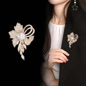 Close-up of elegant flower brooch with pearls, crystals, and delicate tassels