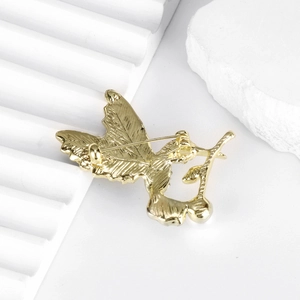 Elegant gold hummingbird brooch with pearl detail shown from a rear safety pin view