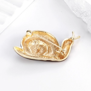 Broche escargot dorée avec texture en spirale détaillée et fermoir épingle classique au dos