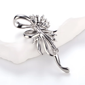 Broche élégante en forme de bouquet de fleurs argenté sur support en pierre blanche