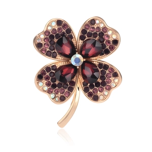 Detail of four-leaf clover brooch with purple crystals and rose gold finish