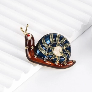 Broche escargot vintage avec finition en émail coloré et cadre en métal doré sur blanc