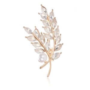 Macro detail of wheat ear brooch with marquise crystals and a white round pearl