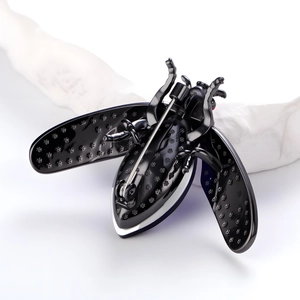 Elegant black beetle brooch with embossed floral wings on minimalist white background