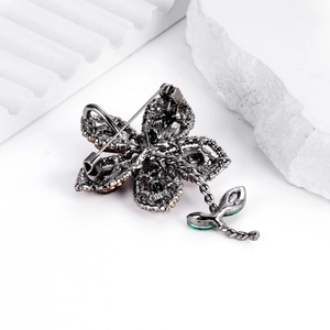 Broche fleur vintage élégante avec cristaux et pendentifs verts vue de l'arrière