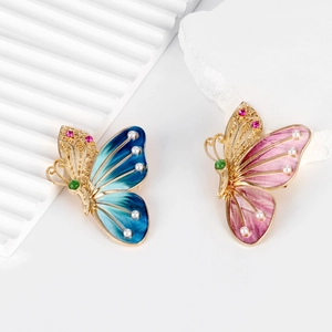 Détail de broches papillons colorées avec émail et petites perles sur alliage doré