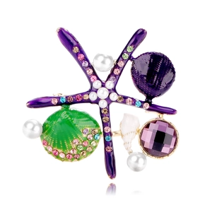 Detail view of starfish brooch with purple enamel, green shell, and white pearls