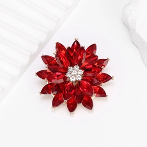 Luxurious lotus flower brooch with red marquise crystals and golden base on white background