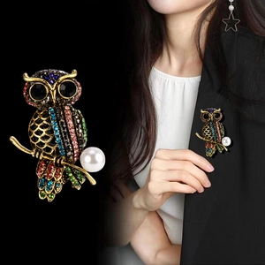 Elegante broche de búho con pedrería de colores y perla en base dorada vintage