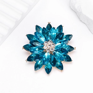 Detailed view of luxury lotus brooch with blue marquise crystals and gold petals