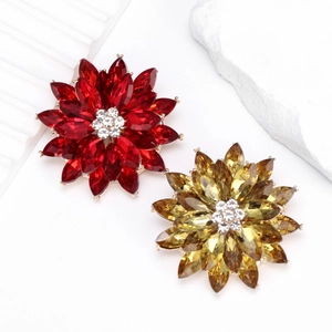 Detailed view of luxury lotus brooches with ruby red and amber crystals in gold settings