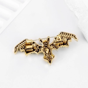 Vintage golden bat brooch showing the detailed back structure and pin closure