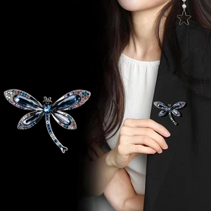 Spilla a libellula di lusso con gemme blu e cristalli colorati su un blazer