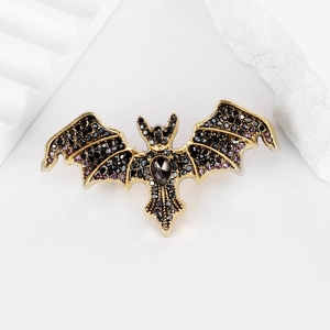 Gothic bat brooch with black rhinestones and purple crystals on gold metal frame