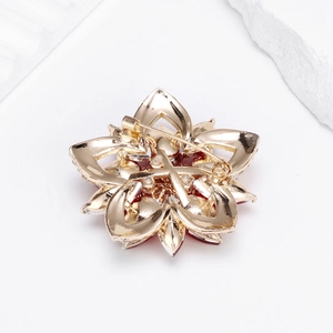 Floral brooch with red gemstone center and gold alloy plating shown from the back view