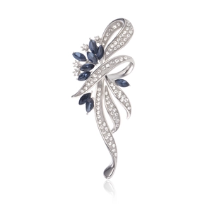Détails d'une broche ruban argentée élégante avec diamants et pierres marquises bleu marine