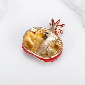 Back view of minimalist gold pomegranate brooch with red enamel and safety pin closure