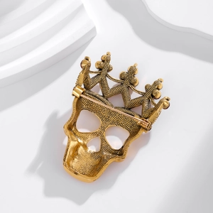 Detailed back view of vintage gold skull crown brooch with pin fastener and textured finish