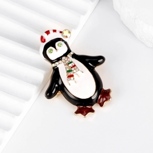 Spilla a pinguino carina in smalto colorato con strass su sfondo bianco geometrico