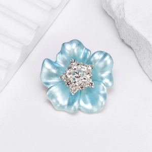 Broche camélia émaillée bleu clair minimaliste avec strass scintillants sur pierre blanche