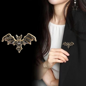 Vintage crystal bat brooch in gold-tone metal with purple diamonds and grey gemstone